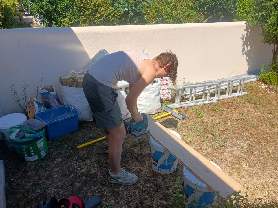 Découpe d’une lame de parquet flottant à l’aide d’une scie pour ajustement en bord de mur