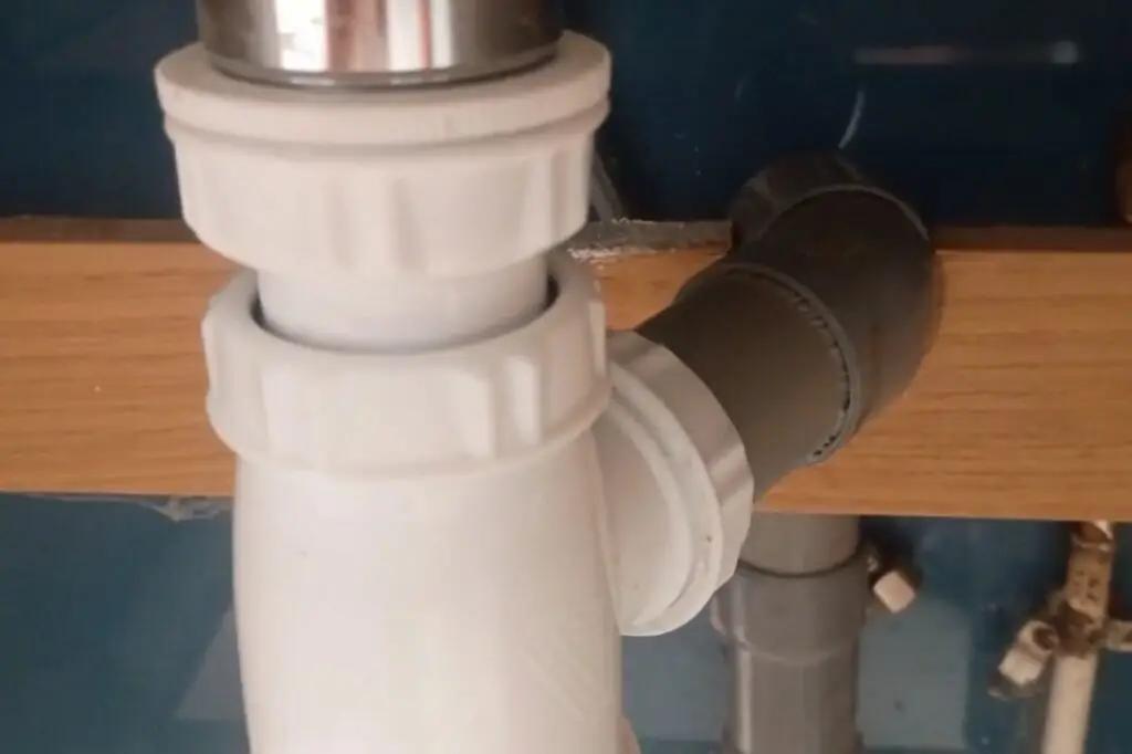 Résultat de l’installation d’une évacuation sous évier dans un meuble de salle de bain, raccordement de plomberie terminé