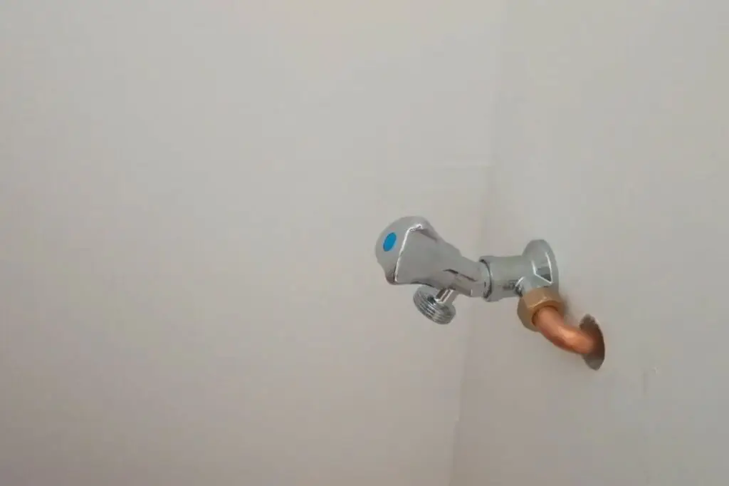Pose finale d’un robinet dans une niche murale de salle de bain pour le raccordement de la machine à laver
