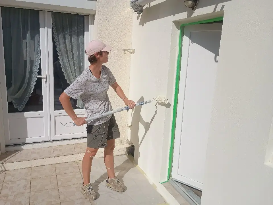 Application de peinture sur une façade extérieure traitée et rénovée pour une finition durable et esthétique.
