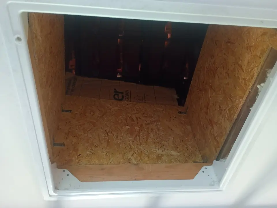 Coffrage en OSB finalisé autour des accès au conduit pour protéger l’isolation et sécuriser les combles