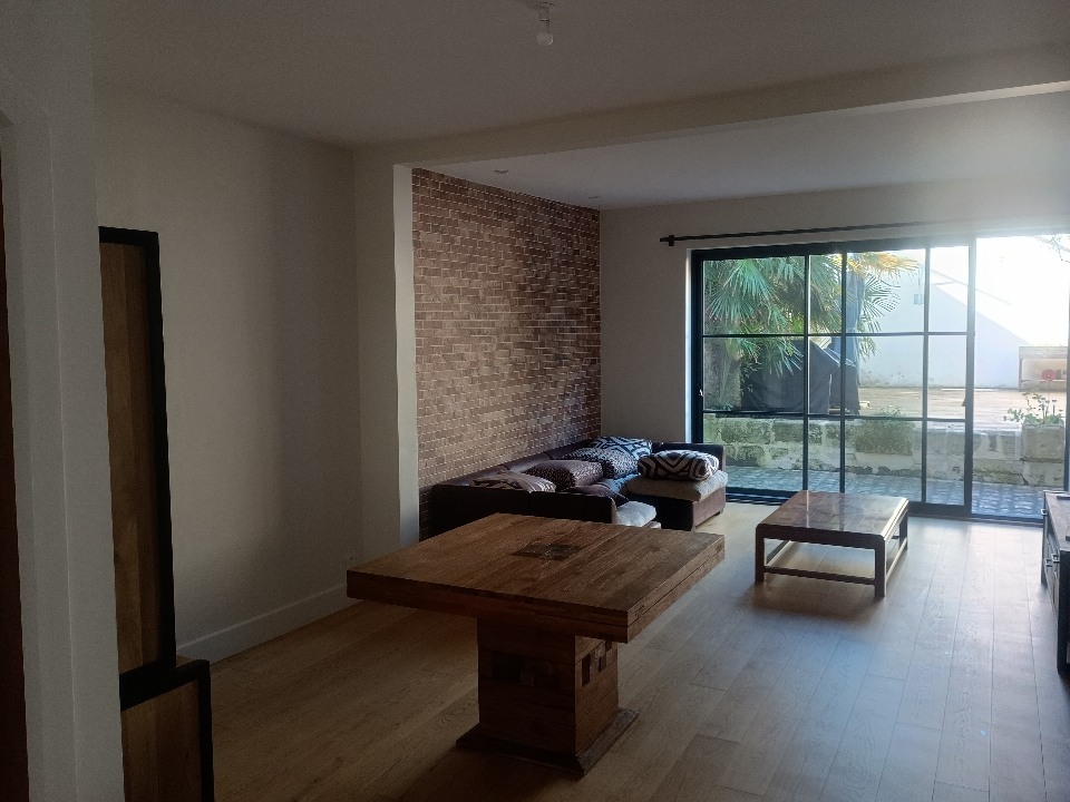 Rénovation peinture d’un salon à Rochefort vue depuis l’entrée, plafond blanc et murs blanc cassé réalisés par un peintre professionnel en Charente-Maritime.