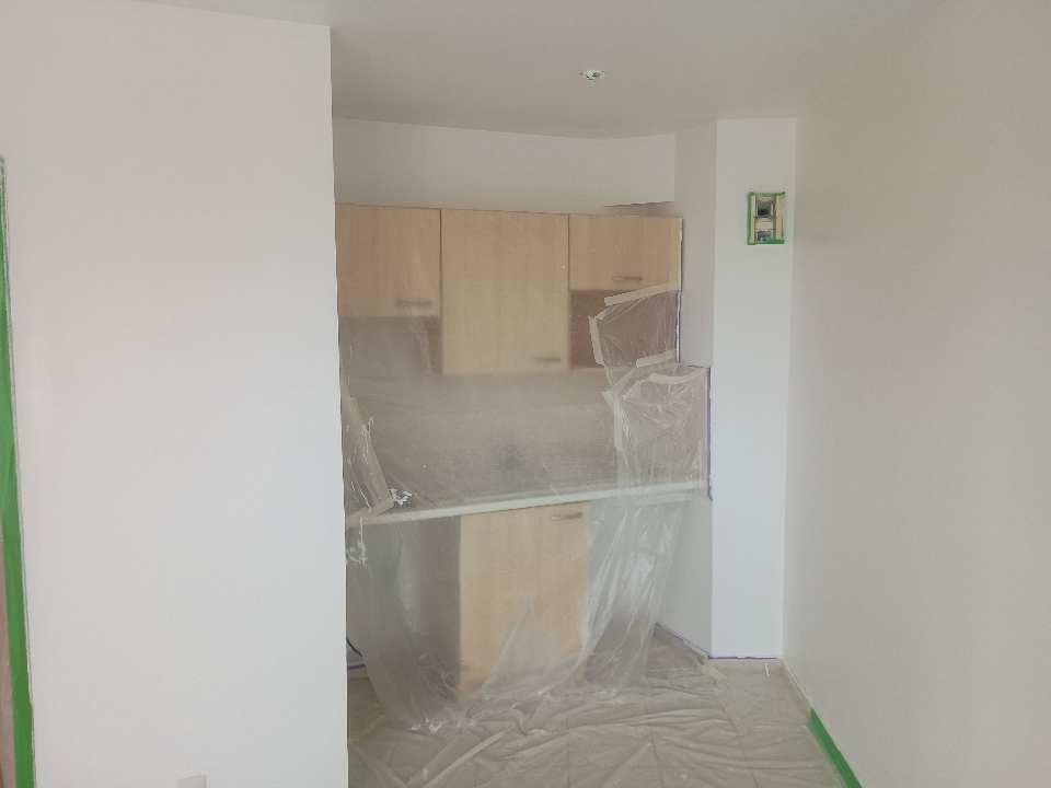Travaux de peinture en cours dans un appartement à La Rochelle avec protection de la cuisine pendant le chantier