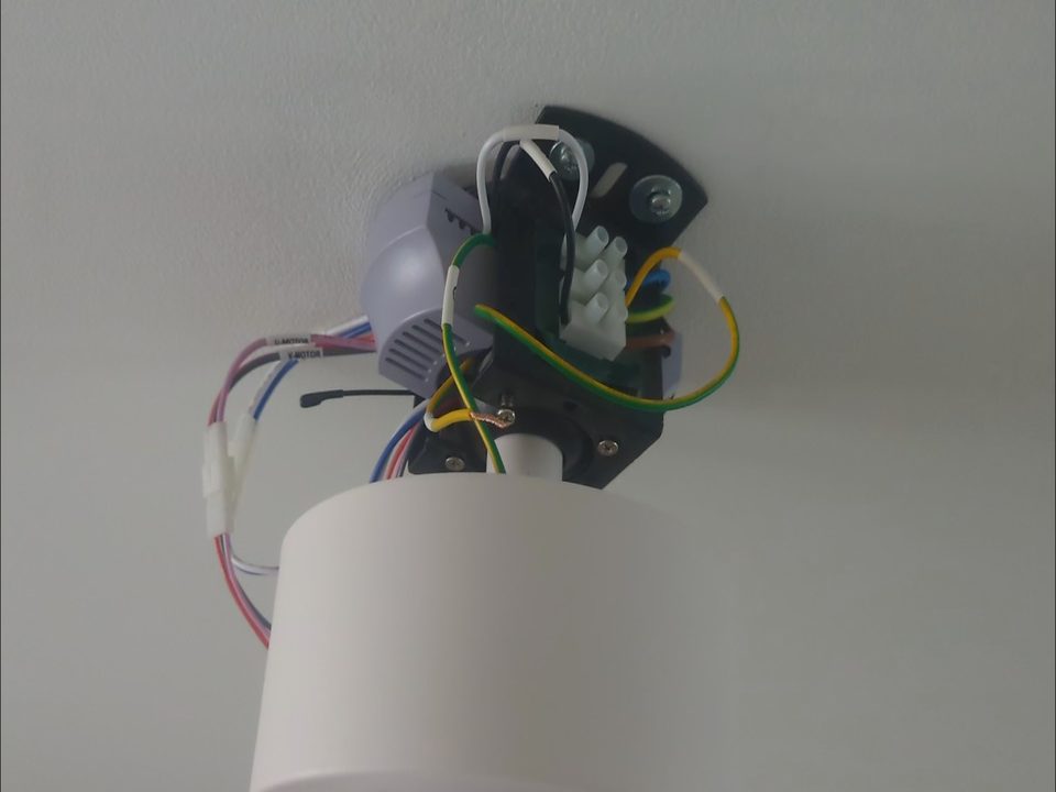 Branchement électrique d'un ventilateur de plafond pendant l'installation.