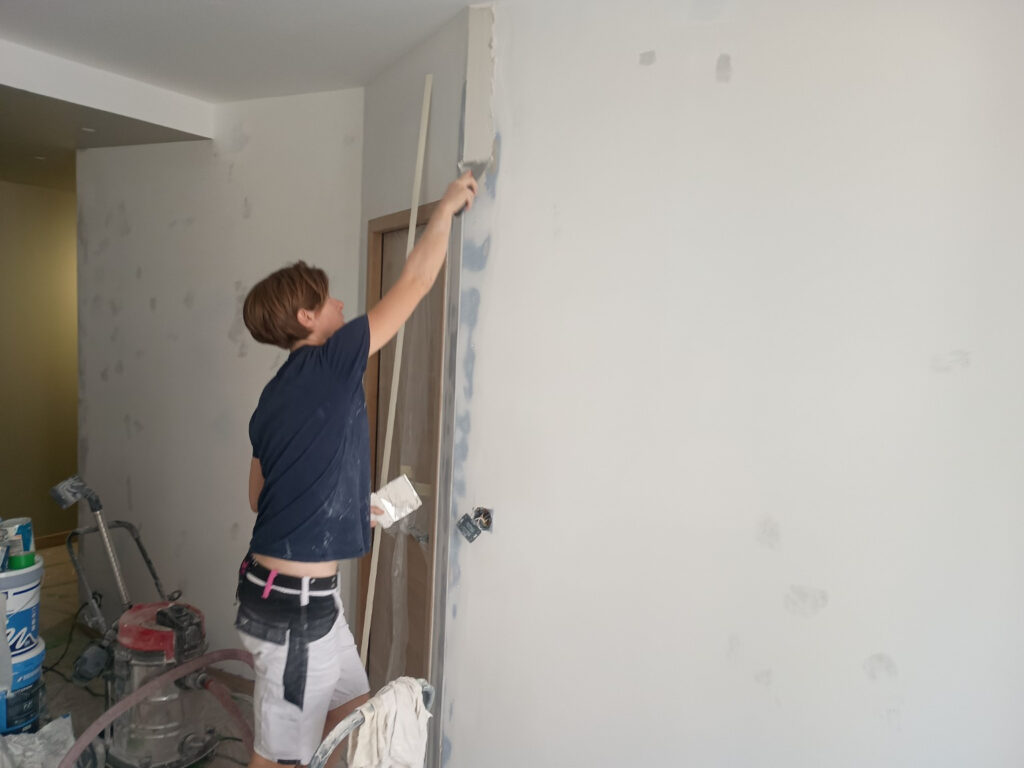 Ratissage d’un mur avant peinture dans un appartement à La Rochelle